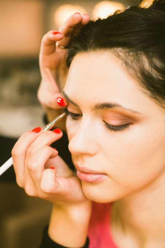 Crop makeup artist applying trendy makeup on model